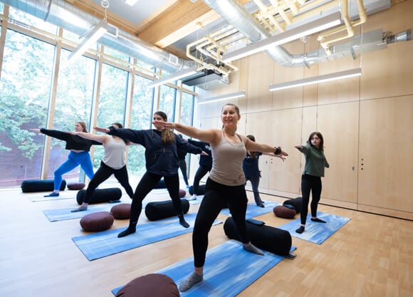 Students stretch on yoga mats during a meditation class