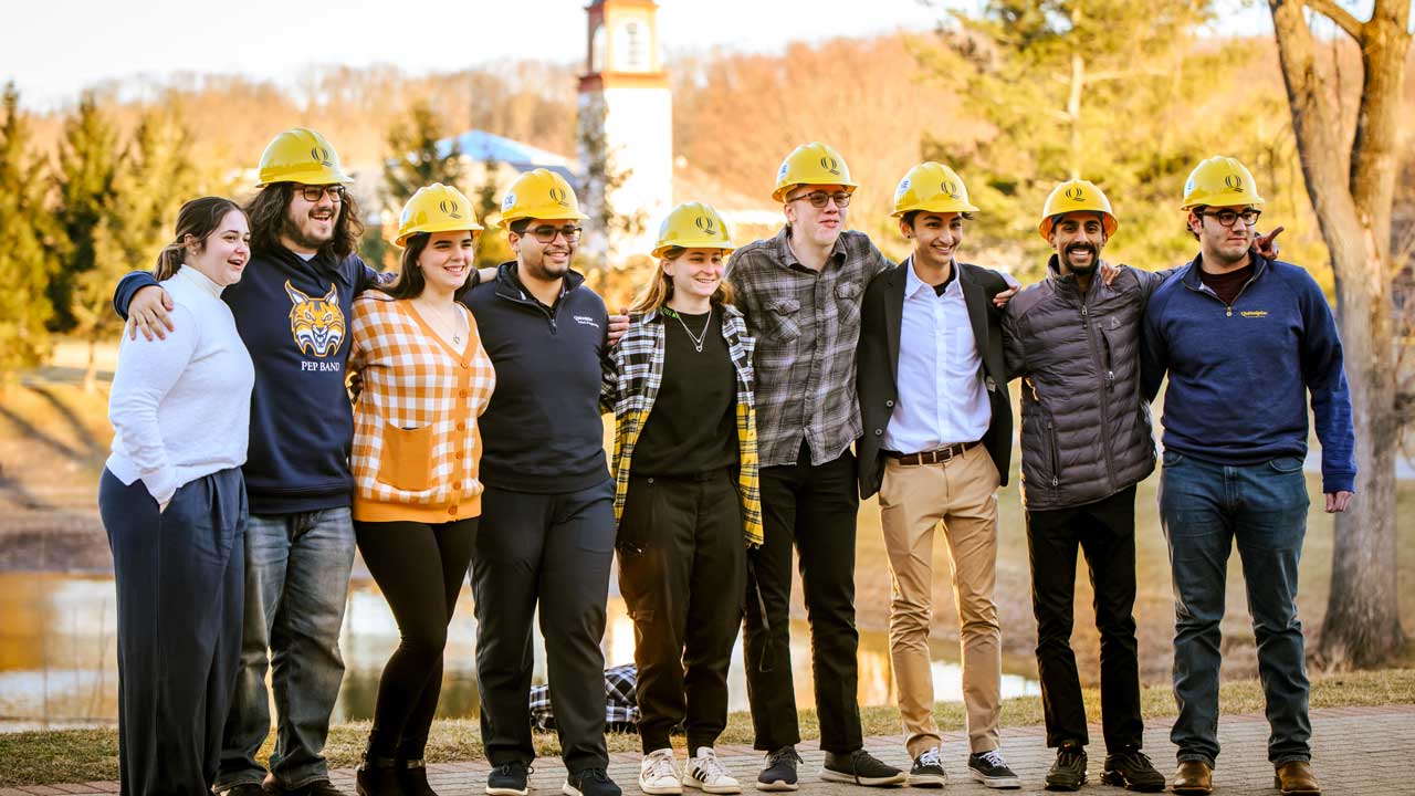 a group of students outside posing for a photo after the hard hat ceremony