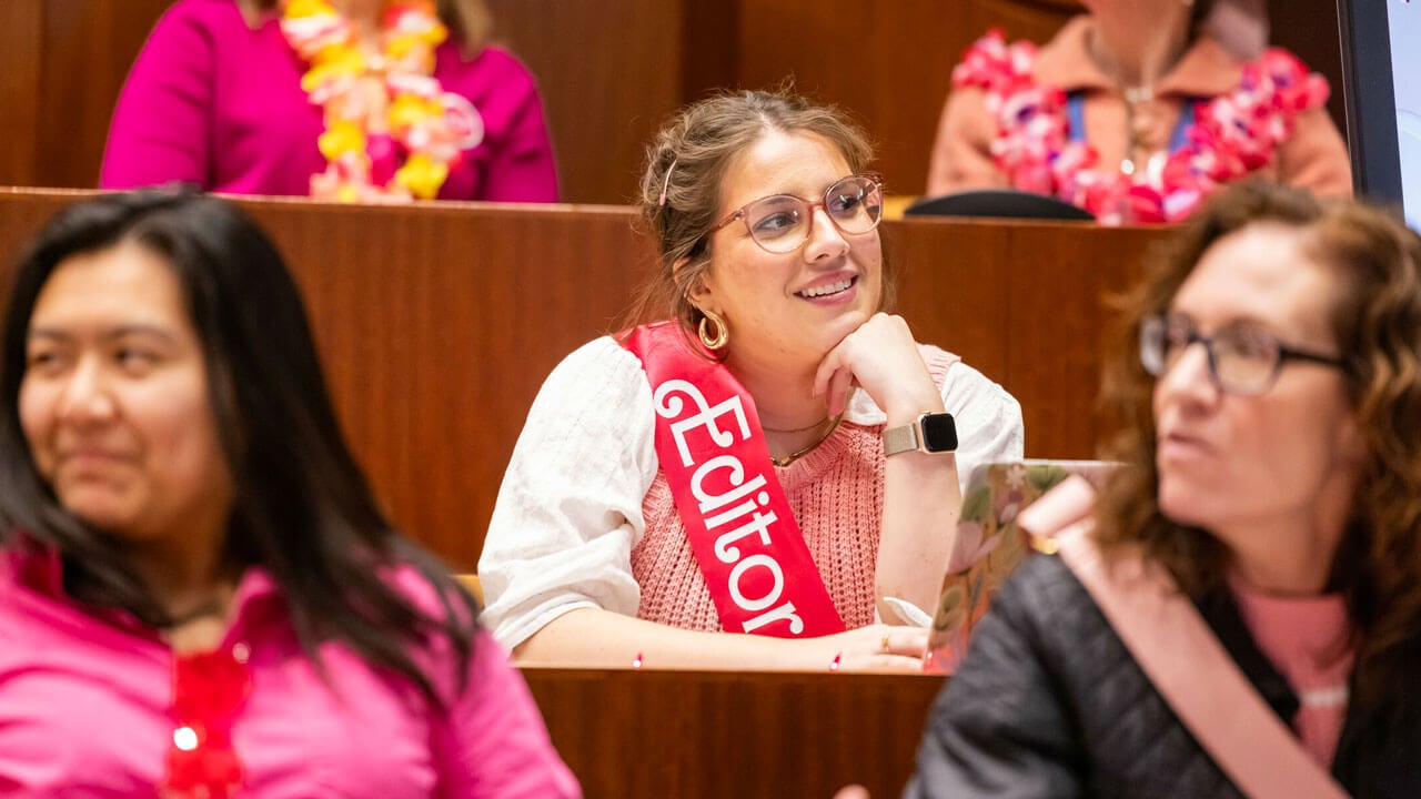 Quinnipiac student wears a pink sash that say "Editor"