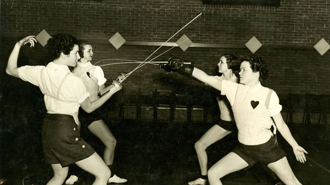 Four women participating in a fencing class