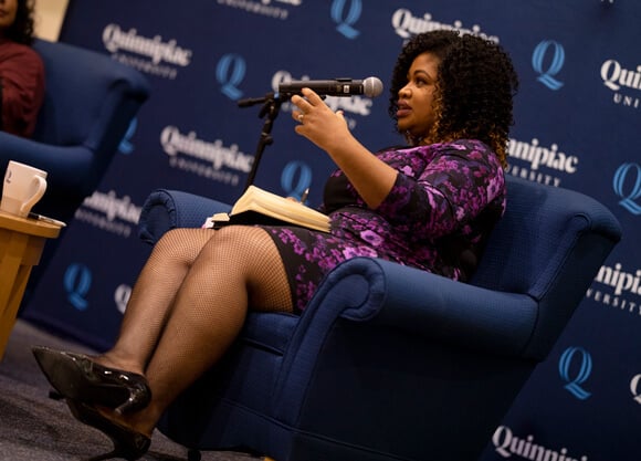 Khalilah Brown-Dean sitting and speaking into a microphone
