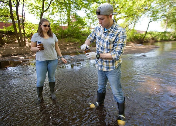 Students retrieve water samples from the Quinnipiac River.