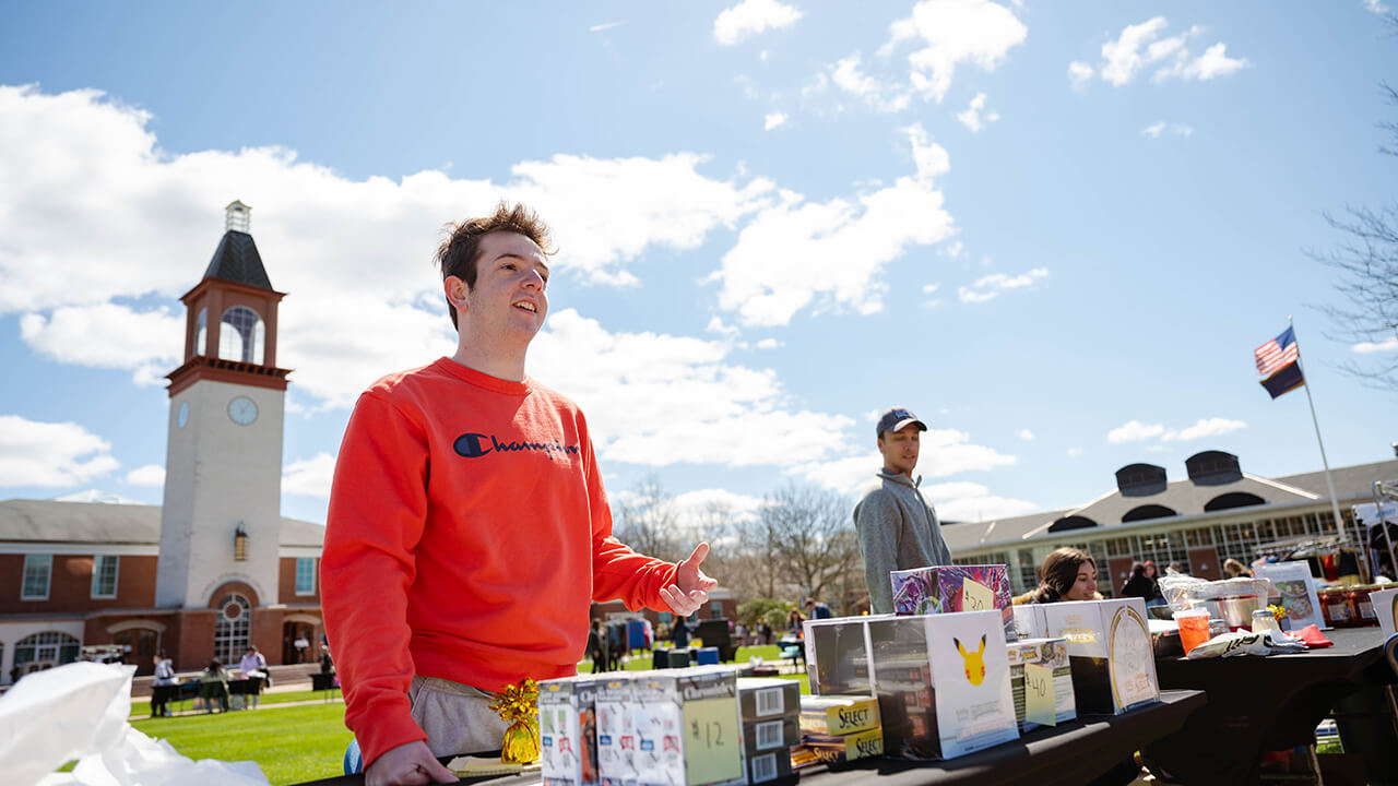 A student gestures to his merchandise.