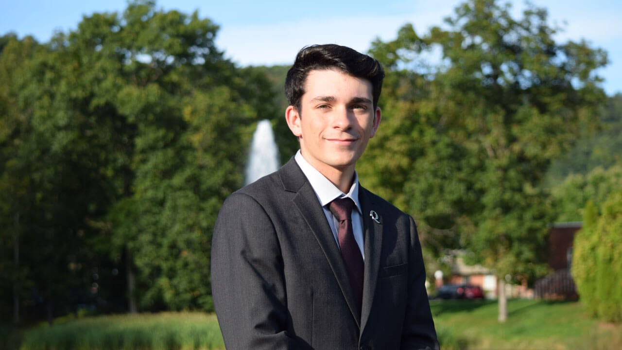 Photo of SGA President J.P.DiDonato outside with the sleeping giant silhouette in the background