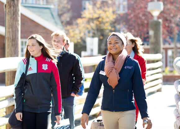 An undergraduate student gives a tour of campus to a prospective student and family