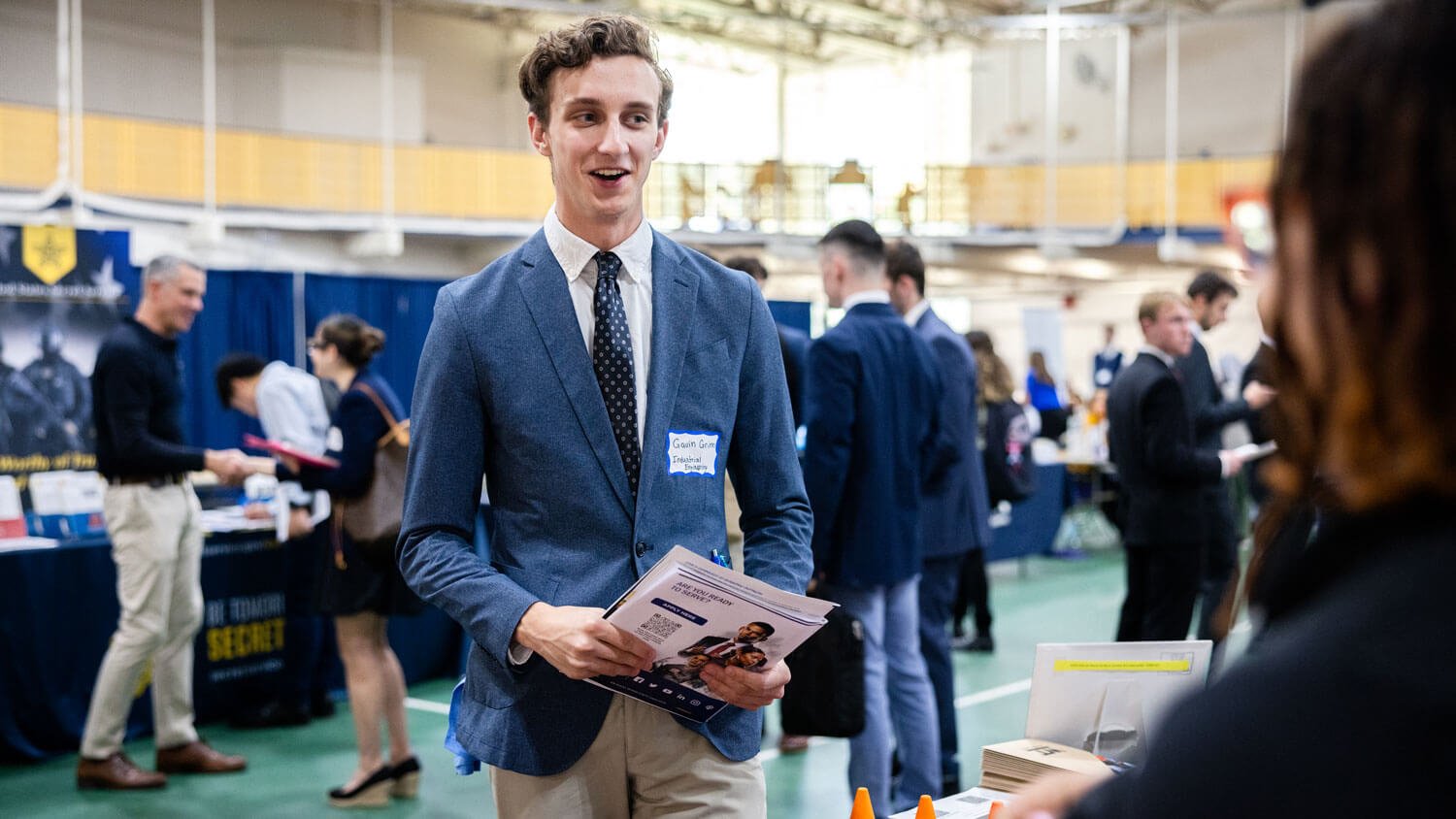 A student interacts with a brand representative during the University career fair.