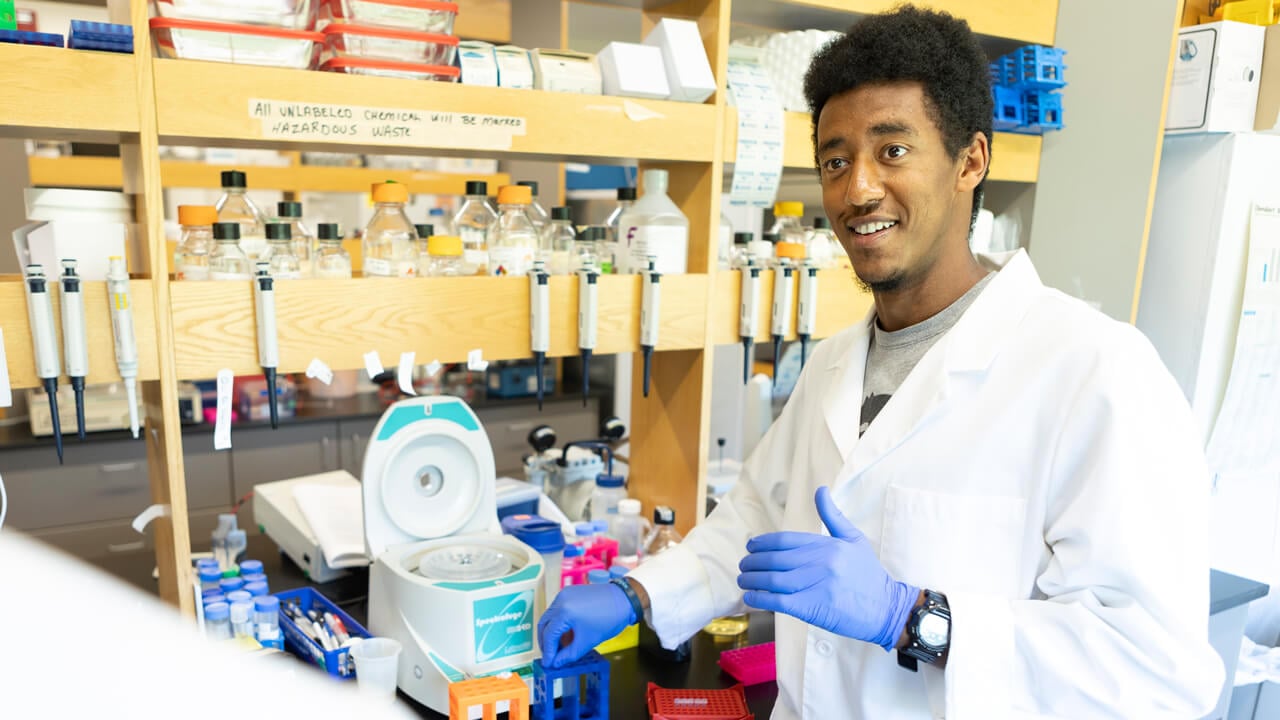 Dagmawi Bogale, biomedical sciences student works in a lab with his professor.