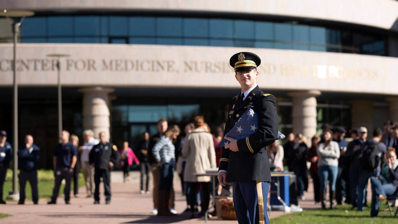 Veteran in front of crowd at center of medicine