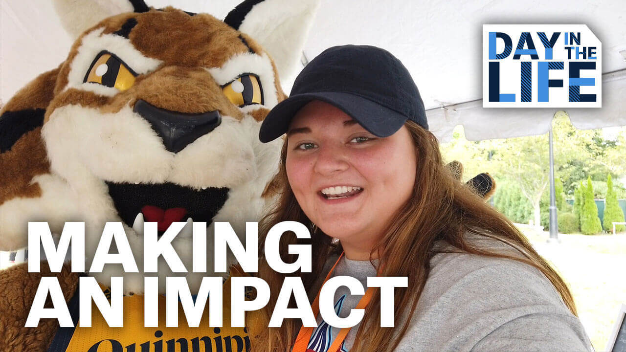 Student poses with Boomer the Bobcat mascot, starts video