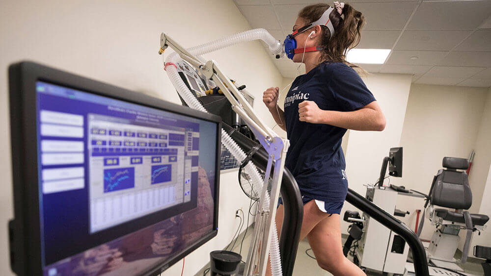 A health sciences student running on a treadmill with a mask in our movement laboratory