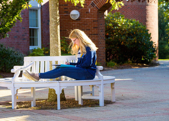 A student studies outside Echlin Center where undergraduate admissions is housed