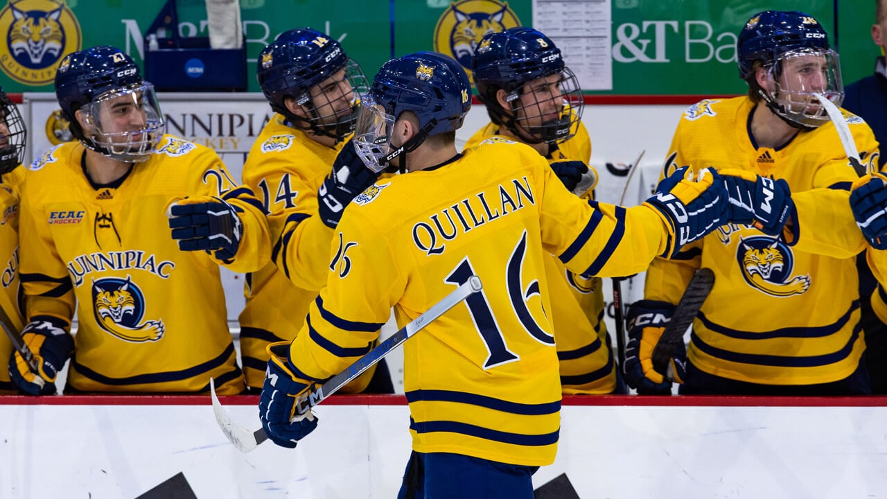 Jacob Quillan high fives his Quinnipiac Bobcats ice hockey teammates as he skates by them
