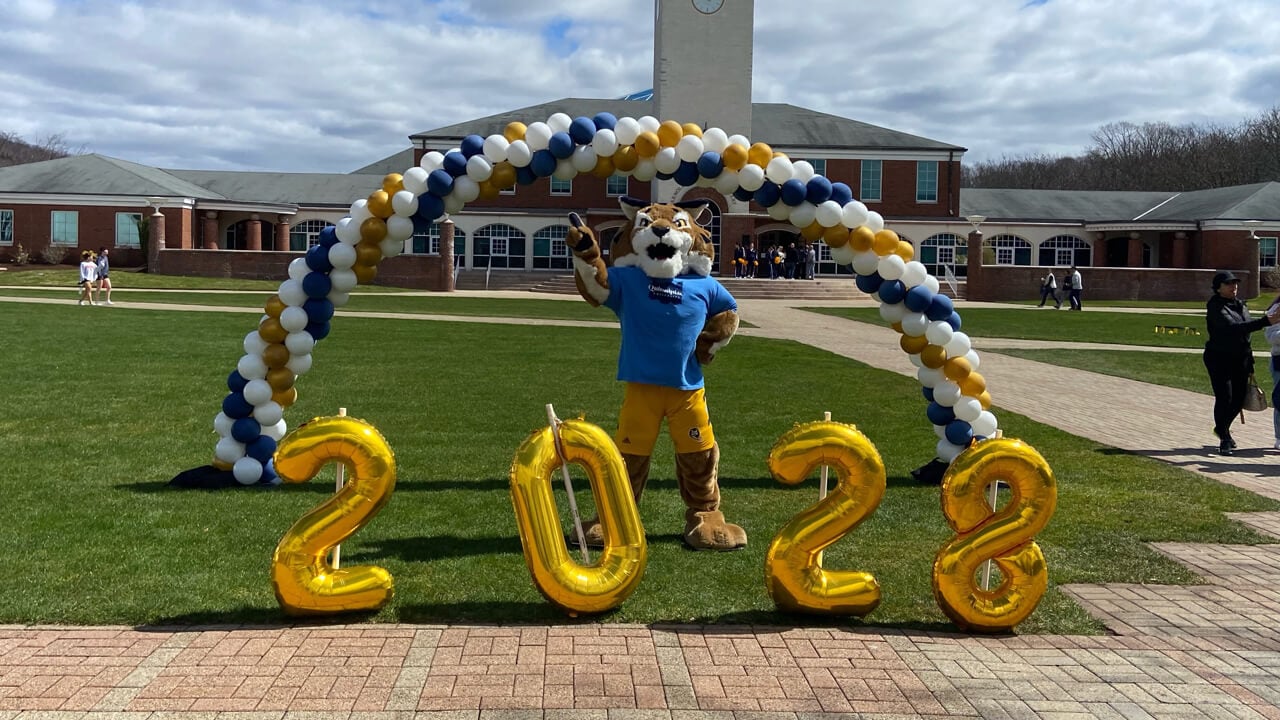 Boomer the mascot poses with balloons that read 2028 on the quad
