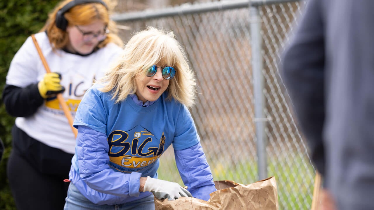 Quinnipiac President Judy Olian carries leaves to a bag