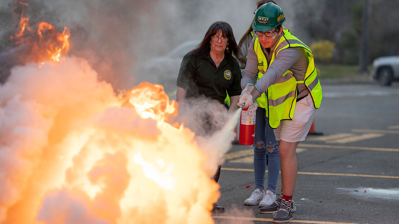 Student extinguishes fire while Hamden CERT member watches