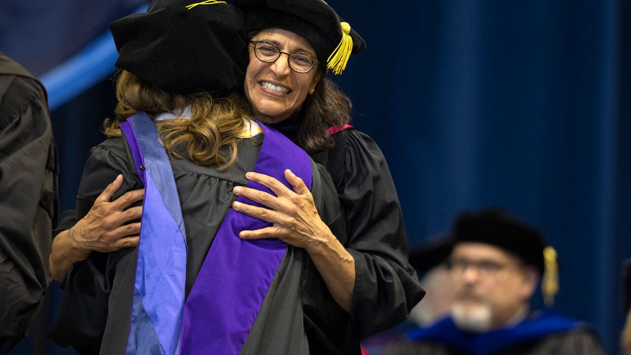 Student hugs professor to show excitement during Law Commencement
