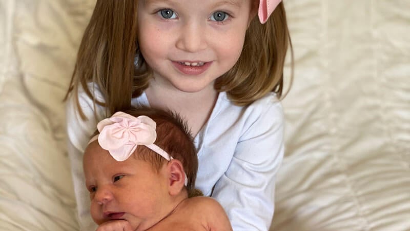 Big sister hold Laramie baby