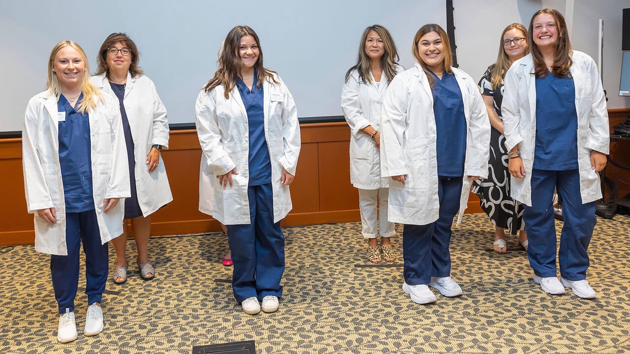 four nursing students pose with their advisors
