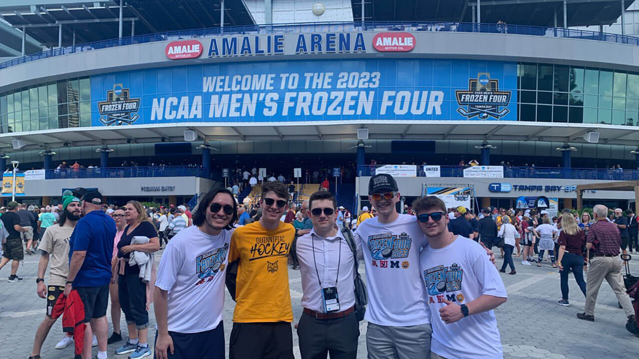 Quinnipiac students stand in front of the Amalie Arena in Tampa, Florida for the hockey national championship.