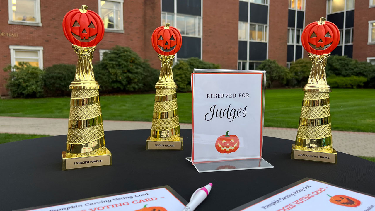 Reserved for judges sign and trophies with jack-o-lanterns sit on top of a table