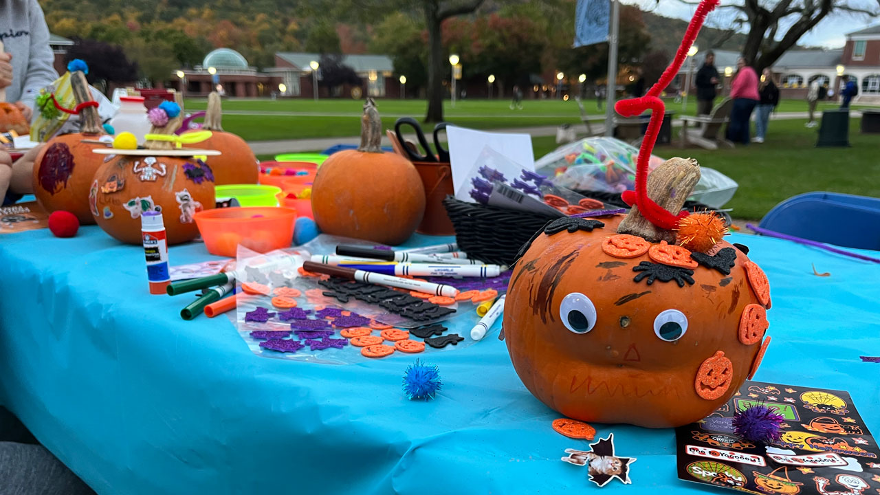 Pumpkins decorated with stickers and markers on a table