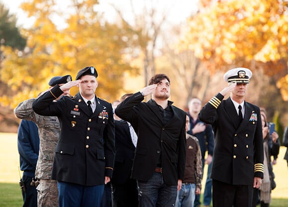Veterans salute the American Flag in honor of Veteran's Day