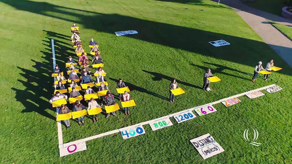 Aerial view of students forming a bar graph, starts video