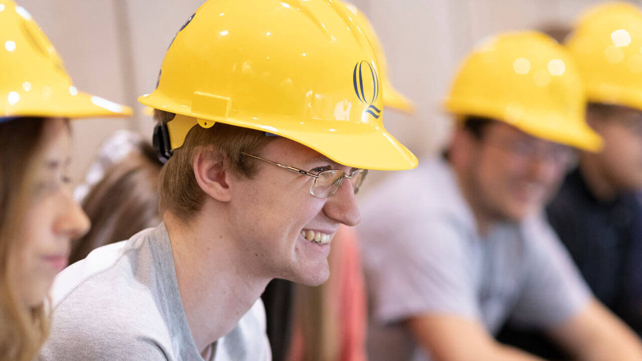 A student smiles during the hard hat ceremony